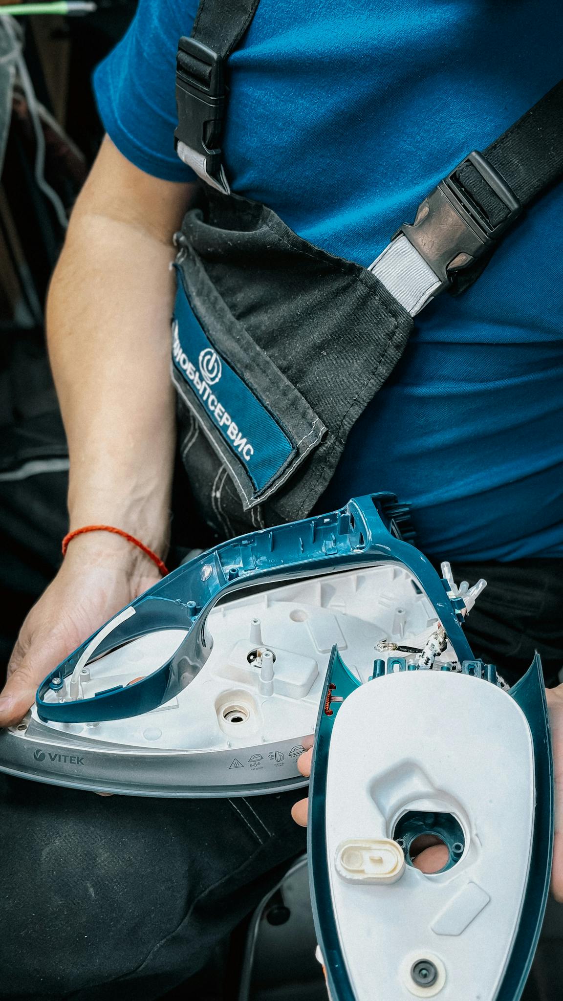 Close Up Of Technician Disassembling An Iron For